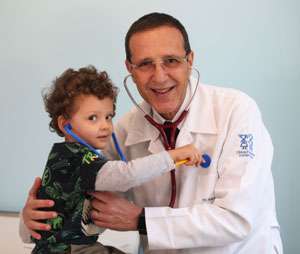 Dr. Mauro atendendo um paciente criança feliz