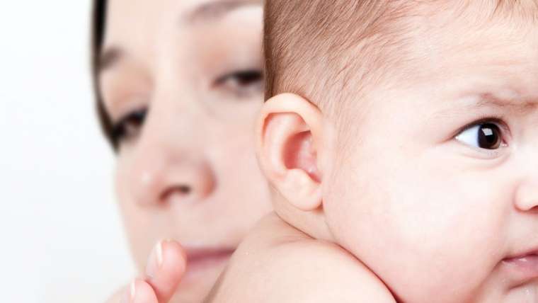 Mãe segurando bebê: doença do refluxo pode causar alguns incômodos