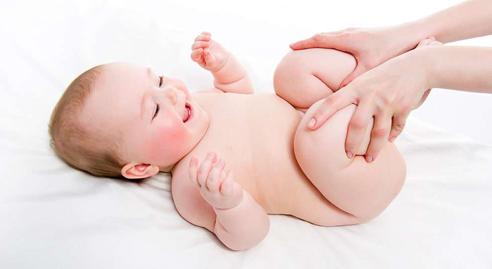 Bebê com cólica recebe massagem de um adulto