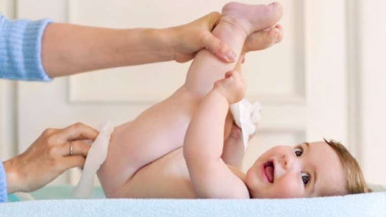 Mulher limpa o bebê; a dermatite de fralda nos bebês é o termo utilizado para descrever a presença de lesões vermelhas inflamatórias na área recoberta pela fralda