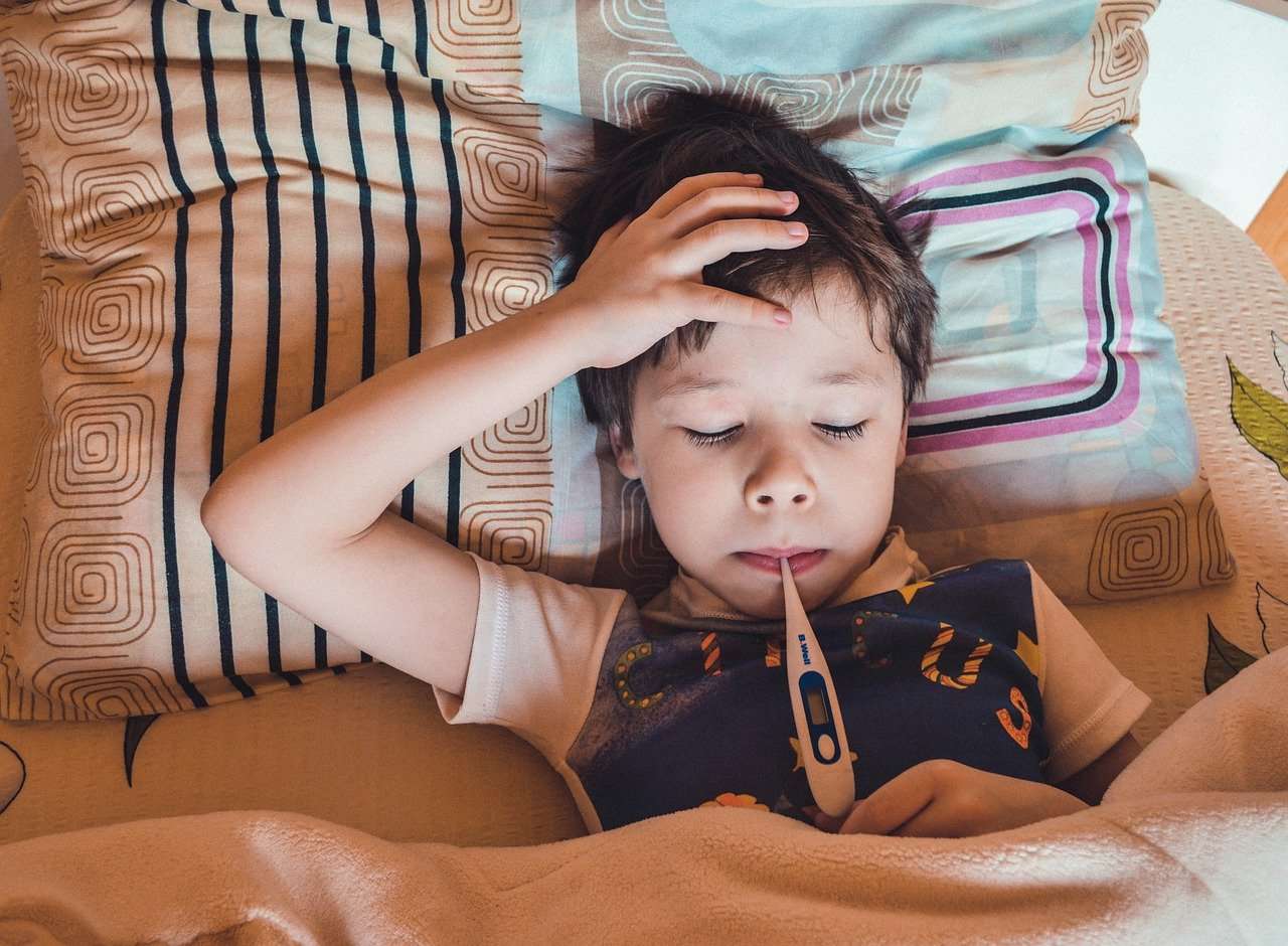 Menino tem sua febre medida com termômetro: é importante manter a criança bem hidratada, aumentando a oferta de líquidos