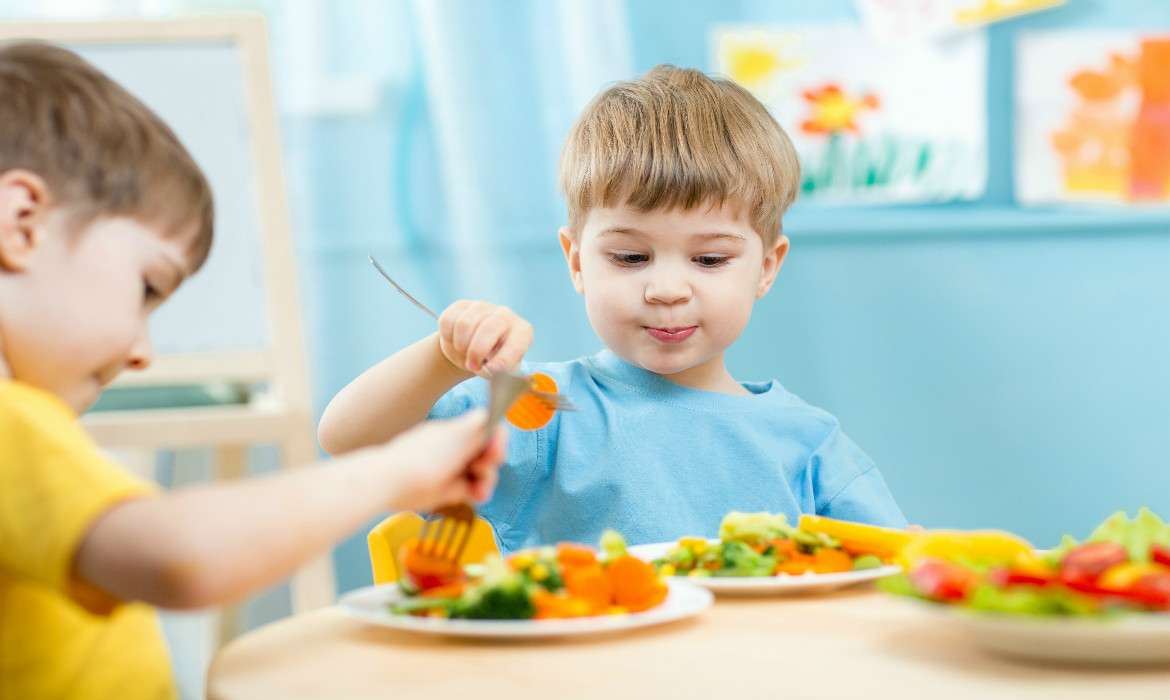 Crianças comendo vegetais e legumes: pais têm que ser críticos com as propagandas de alimentos e notícias divulgadas em mídias e redes sociais 
